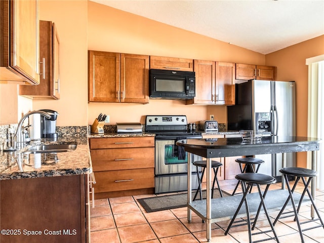 1277 S Orlando Ave Unit 4B, Cocoa Beach, FL 32931 - kitchen featuring black microwave, stainless steel range with electric stovetop, lofted ceiling, fridge with ice dispenser, and brown cabinetry