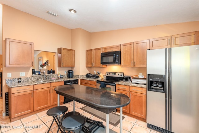 1277 S Orlando Ave Unit 4B, Cocoa Beach, FL 32931 - kitchen with black appliances, lofted ceiling, light tile patterned floors, and light stone countertops