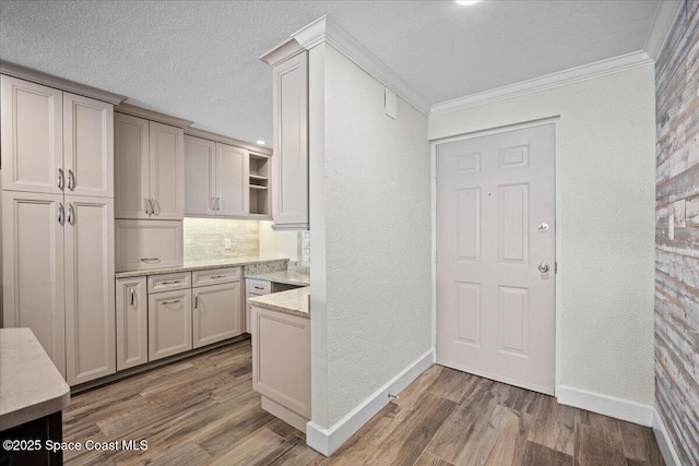 3221 S Atlantic Ave Unit 703, Cocoa Beach, FL 32931 - kitchen with open shelves, a textured ceiling, wood finished floors, a textured wall, and light stone counters