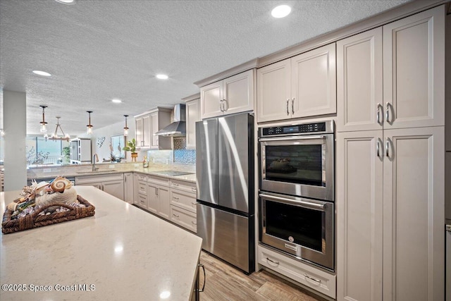 3221 S Atlantic Ave Unit 703, Cocoa Beach, FL 32931 - kitchen with appliances with stainless steel finishes, wall chimney exhaust hood, light wood-type flooring, recessed lighting, and a textured ceiling