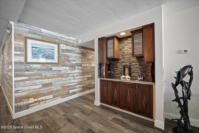3221 S Atlantic Ave Unit 703, Cocoa Beach, FL 32931 - bar featuring wooden walls, a textured ceiling, dark wood-style floors, and decorative backsplash