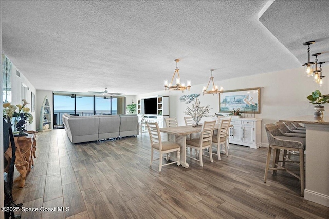 3221 S Atlantic Ave Unit 703, Cocoa Beach, FL 32931 - dining area featuring wood finished floors, a textured ceiling, a chandelier, and ceiling fan