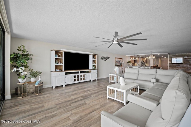 3221 S Atlantic Ave Unit 703, Cocoa Beach, FL 32931 - living room featuring a ceiling fan, wood finished floors, a textured ceiling, and a chandelier