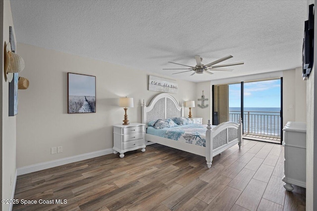 3221 S Atlantic Ave Unit 703, Cocoa Beach, FL 32931 - bedroom featuring access to outside, wood finished floors, a textured ceiling, and a ceiling fan