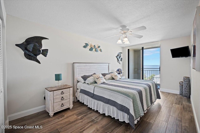 3221 S Atlantic Ave Unit 703, Cocoa Beach, FL 32931 - bedroom with access to exterior, dark wood finished floors, a textured ceiling, and ceiling fan