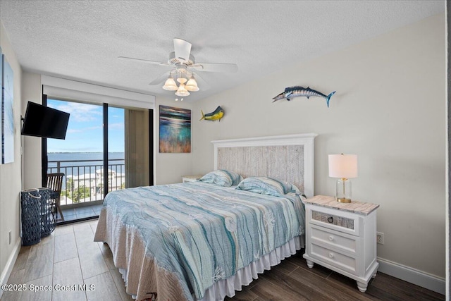 3221 S Atlantic Ave Unit 703, Cocoa Beach, FL 32931 - bedroom featuring access to outside, wood finished floors, a textured ceiling, and a ceiling fan