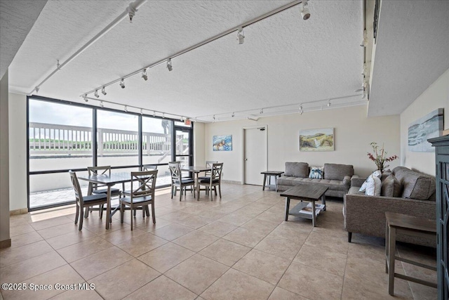 3221 S Atlantic Ave Unit 703, Cocoa Beach, FL 32931 - living room with rail lighting, light tile patterned floors, and a textured ceiling