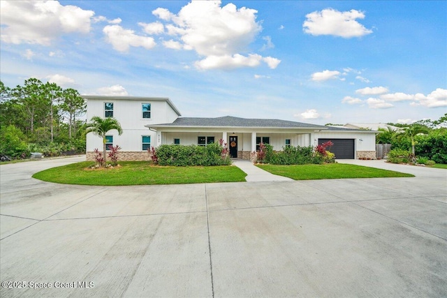 6190 Brabrook Ave, Grant, FL 32949 - view of front facade featuring driveway, a front lawn, a garage, a porch, and stone siding
