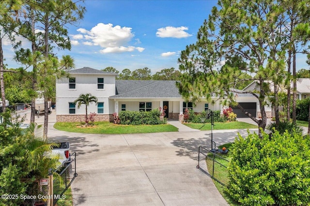6190 Brabrook Ave, Grant, FL 32949 - view of front of home with stone siding, stucco siding, driveway, a shingled roof, and an attached garage