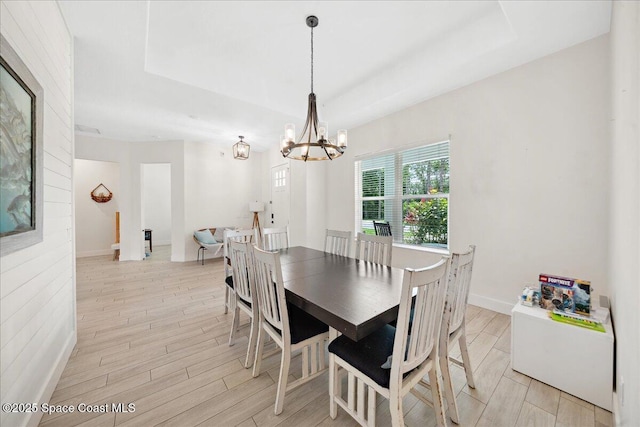 6190 Brabrook Ave, Grant, FL 32949 - dining room featuring a tray ceiling, light wood-style flooring, and a chandelier