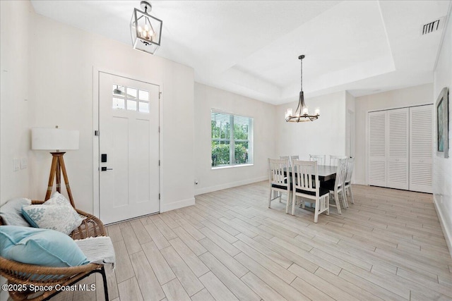 6190 Brabrook Ave, Grant, FL 32949 - entrance foyer featuring a chandelier, light wood-type flooring, and a raised ceiling