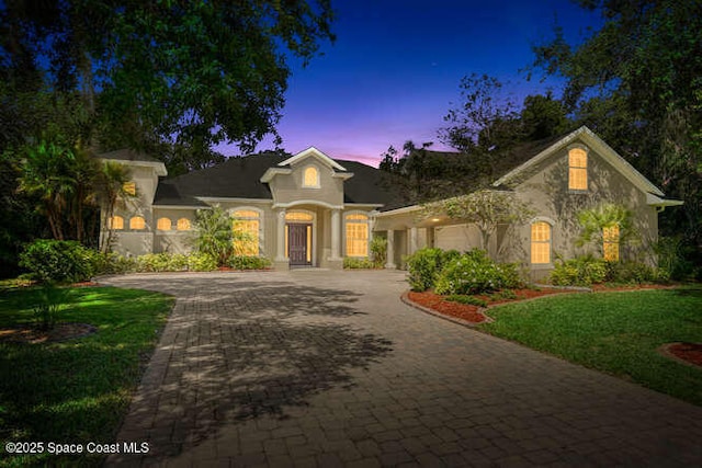 4356 Davidia Dr, Melbourne, FL 32934 - view of front of house featuring decorative driveway, an attached garage, a front lawn, and stucco siding