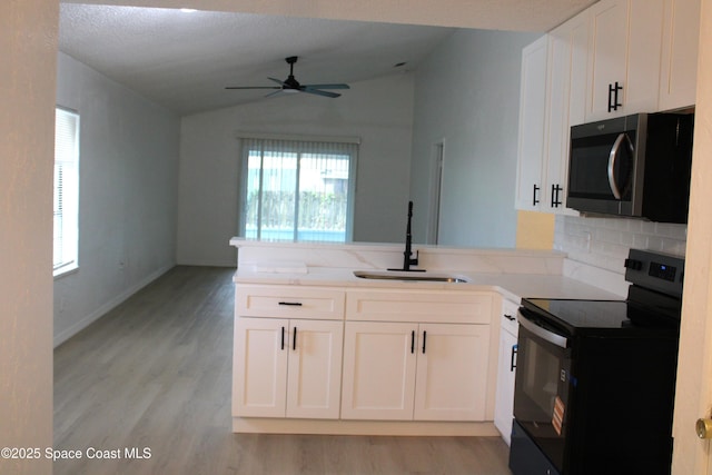 1001 Bernice Rd, Rockledge, FL 32955 - kitchen with stainless steel microwave, electric range, vaulted ceiling, a peninsula, and a ceiling fan