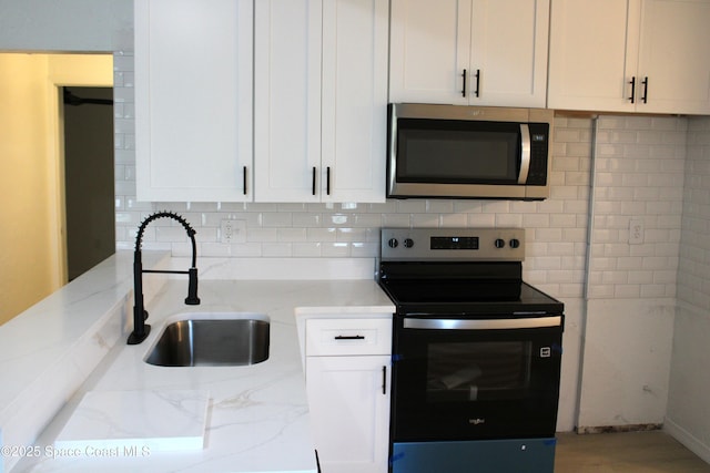 1001 Bernice Rd, Rockledge, FL 32955 - kitchen featuring stainless steel microwave, black range with electric stovetop, light stone counters, and tasteful backsplash