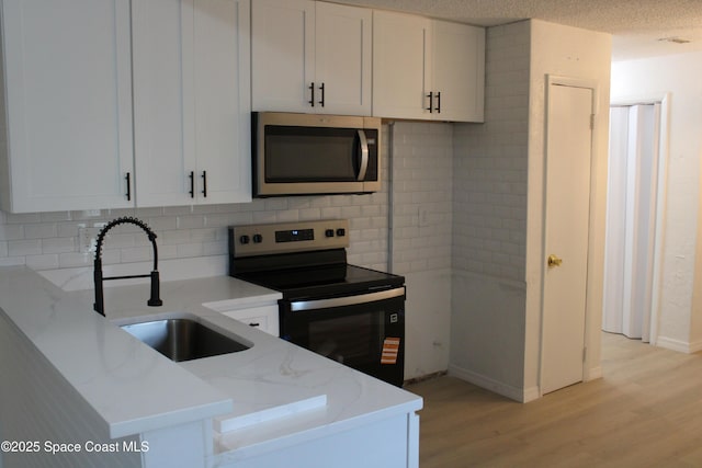 1001 Bernice Rd, Rockledge, FL 32955 - kitchen with appliances with stainless steel finishes, light wood-style flooring, light stone counters, and tasteful backsplash