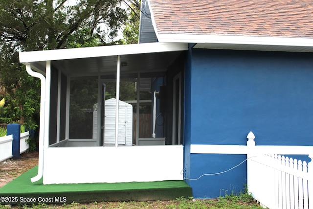 1001 Bernice Rd, Rockledge, FL 32955 - view of side of property featuring a shingled roof, a sunroom, and a shed