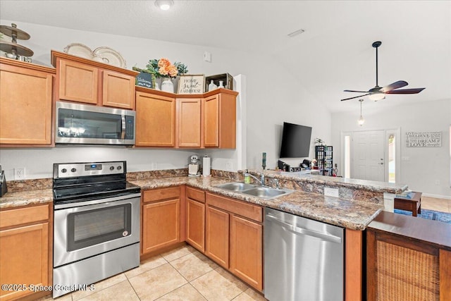 5575 Hemsing St, Cocoa, FL 32927 - kitchen with stainless steel appliances, vaulted ceiling, a peninsula, a ceiling fan, and light tile patterned floors