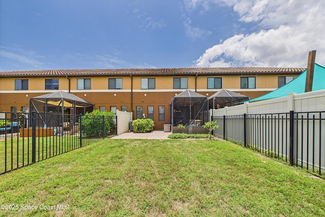 152 Clemente Dr, Satellite Beach, FL 32937 - back of house featuring a fenced backyard, a tiled roof, stucco siding, and a gazebo