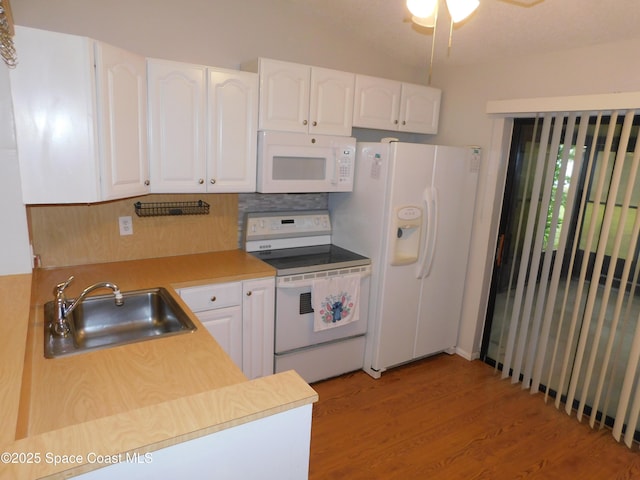 1679 Cardinal Ct, Melbourne, FL 32935 - kitchen featuring white appliances, decorative backsplash, white cabinets, light wood-style floors, and lofted ceiling