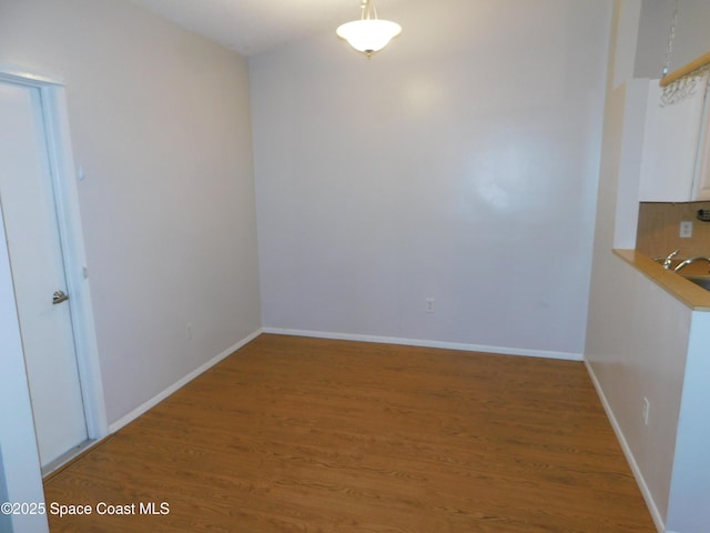 1679 Cardinal Ct, Melbourne, FL 32935 - unfurnished dining area with wood finished floors and baseboards