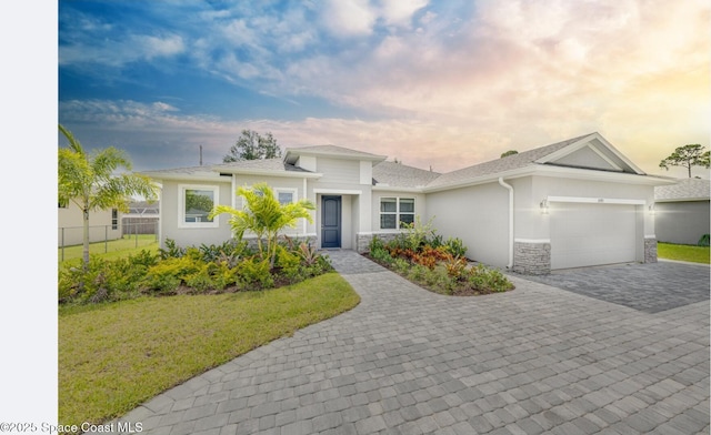 210 La Gore St, Palm Bay, FL 32908 - view of front of home with decorative driveway, stucco siding, an attached garage, stone siding, and roof with shingles