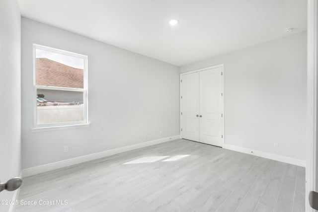 210 La Gore St, Palm Bay, FL 32908 - unfurnished bedroom featuring light wood-style floors, a closet, and recessed lighting