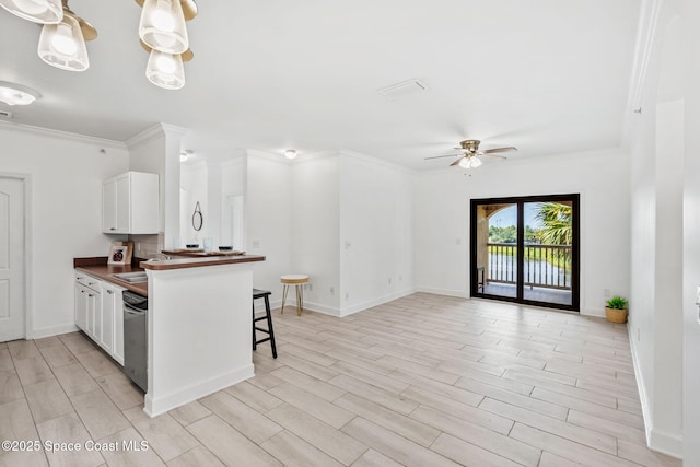 6461 Borasco Dr Unit 3808, Melbourne, FL 32940 - kitchen featuring a ceiling fan, dark countertops, crown molding, a peninsula, and white cabinetry