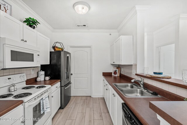 6461 Borasco Dr Unit 3808, Melbourne, FL 32940 - kitchen with stainless steel appliances, dark countertops, tasteful backsplash, white cabinets, and crown molding