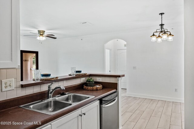6461 Borasco Dr Unit 3808, Melbourne, FL 32940 - kitchen with dark countertops, stainless steel dishwasher, arched walkways, a ceiling fan, and white cabinetry