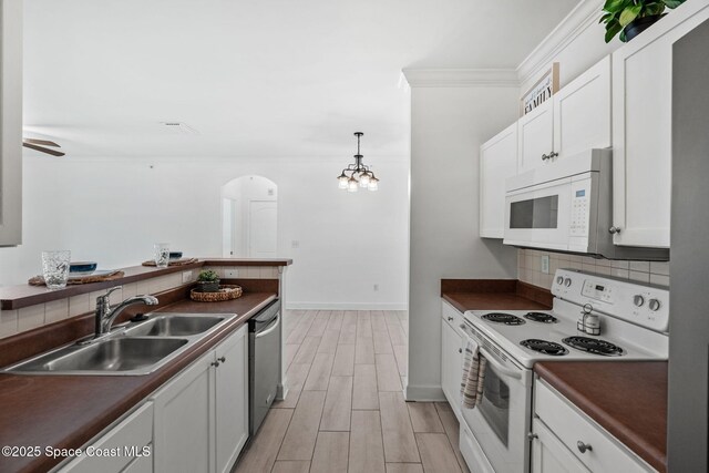 6461 Borasco Dr Unit 3808, Melbourne, FL 32940 - kitchen with white appliances, dark countertops, white cabinets, arched walkways, and backsplash
