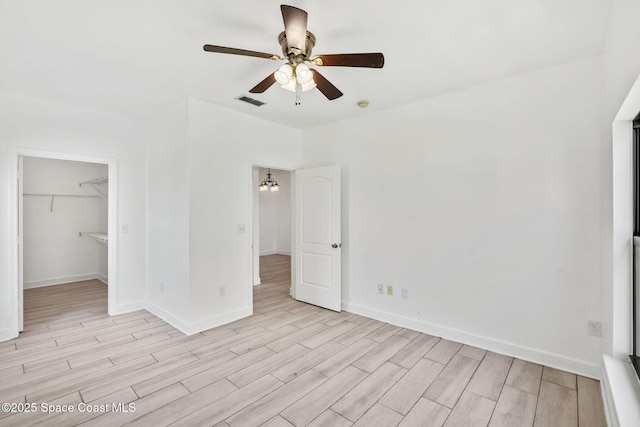 6461 Borasco Dr Unit 3808, Melbourne, FL 32940 - unfurnished bedroom with light wood-style floors, a walk in closet, and a ceiling fan