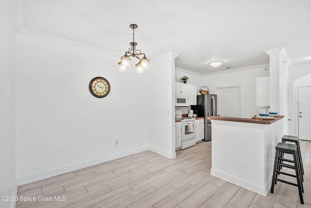 6461 Borasco Dr Unit 3808, Melbourne, FL 32940 - kitchen with white appliances, crown molding, a breakfast bar area, light wood-style floors, and a peninsula