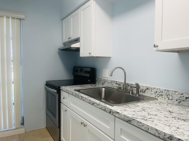 250 N Banana River Dr Unit F-11, Merritt Island, FL 32952 - kitchen with electric range, under cabinet range hood, light countertops, and white cabinetry