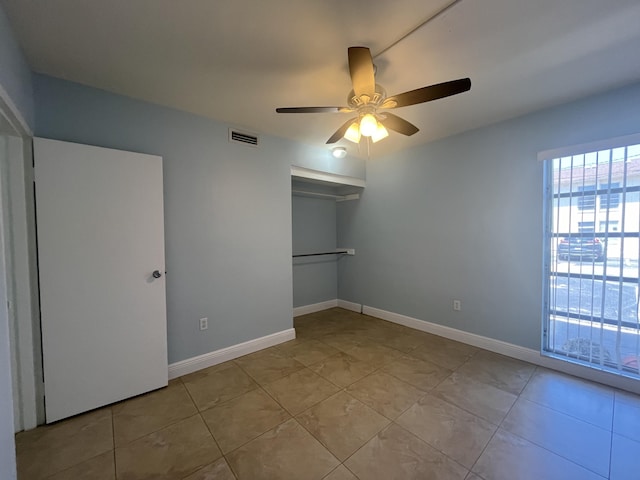 250 N Banana River Dr Unit F-11, Merritt Island, FL 32952 - unfurnished bedroom featuring light tile patterned flooring, a closet, and ceiling fan
