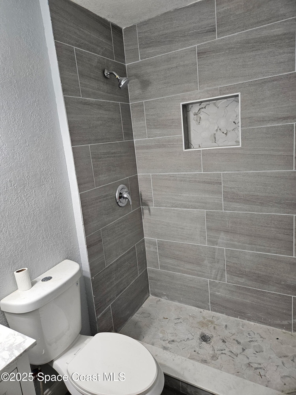 2062 E Cedarwood Dr, Melbourne, FL 32935 - full bathroom featuring a shower stall, vanity, and a textured wall