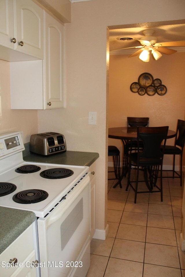 350 Taylor Ave Unit 11B2, Cape Canaveral, FL 32920 - kitchen featuring white range with electric cooktop, white cabinetry, light tile patterned flooring, ceiling fan, and dark countertops