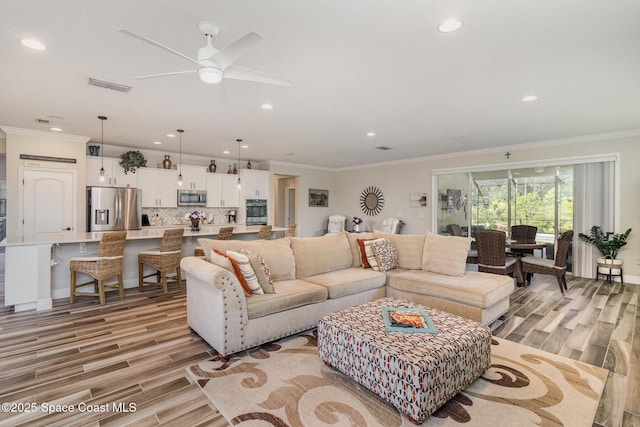 4014 Preservation Cir, Melbourne, FL 32934 - living room with light wood finished floors, a ceiling fan, crown molding, and recessed lighting