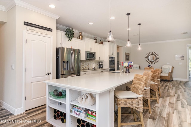 4014 Preservation Cir, Melbourne, FL 32934 - kitchen featuring stainless steel appliances, crown molding, white cabinetry, backsplash, and light wood finished floors