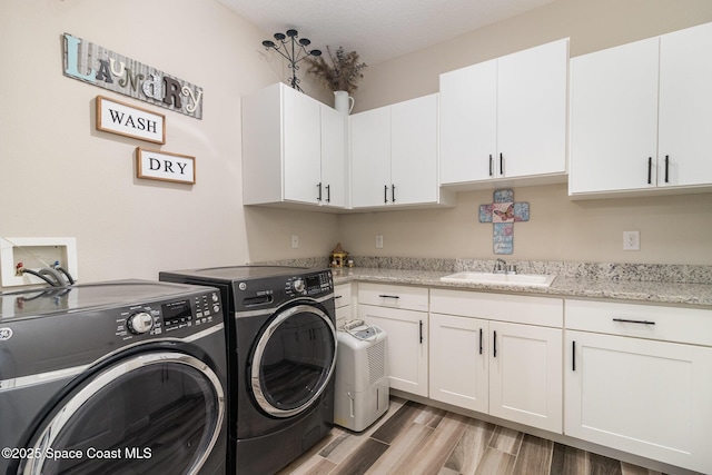 4014 Preservation Cir, Melbourne, FL 32934 - washroom featuring washer and dryer, cabinet space, and light wood-style flooring