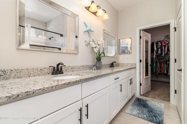 4014 Preservation Cir, Melbourne, FL 32934 - bathroom with double vanity, a shower stall, a walk in closet, and tile patterned flooring