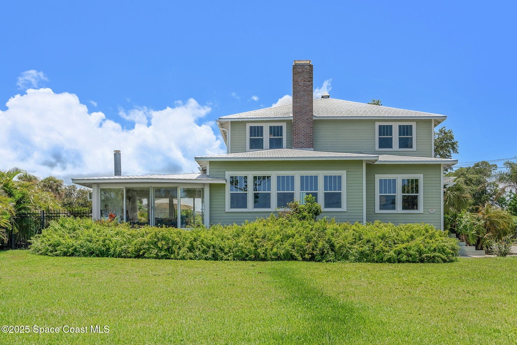 2907 N Indian River Dr, Cocoa, FL 32922 - back of house featuring a chimney and a sunroom