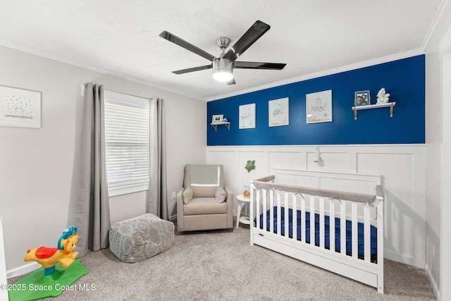 416 Catalina Ave NW, Palm Bay, FL 32907 - carpeted bedroom featuring a nursery area, crown molding, wainscoting, a decorative wall, and ceiling fan