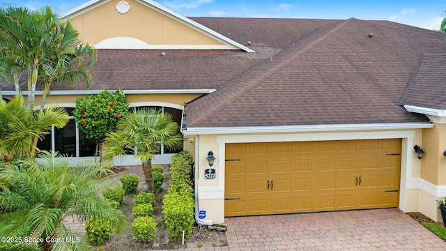 5727 Tamarac Dr, Melbourne, FL 32940 - view of front of home featuring stucco siding, a garage, a shingled roof, and driveway