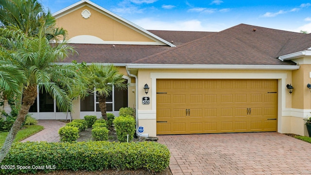5727 Tamarac Dr, Melbourne, FL 32940 - view of front of property featuring stucco siding, an attached garage, and driveway