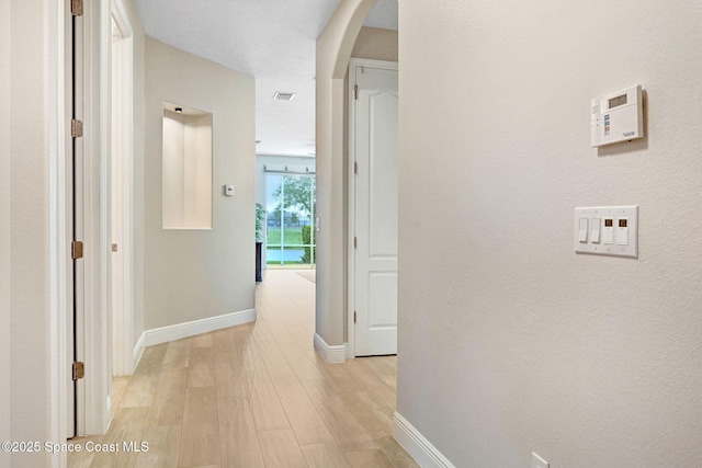5727 Tamarac Dr, Melbourne, FL 32940 - hallway featuring arched walkways and light wood-style floors