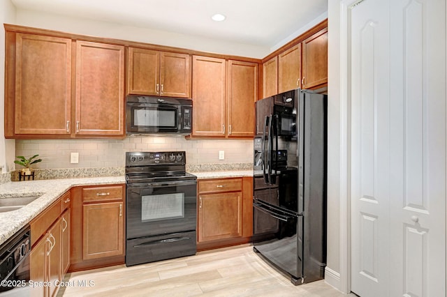5727 Tamarac Dr, Melbourne, FL 32940 - kitchen with black appliances, light stone countertops, brown cabinetry, decorative backsplash, and recessed lighting