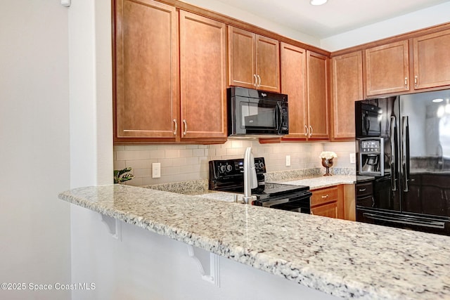 5727 Tamarac Dr, Melbourne, FL 32940 - kitchen with black appliances, tasteful backsplash, light stone counters, and recessed lighting