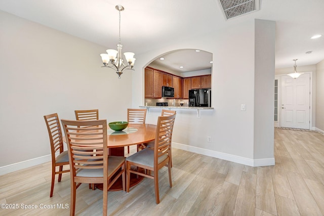 5727 Tamarac Dr, Melbourne, FL 32940 - dining area with light wood-style floors, recessed lighting, a chandelier, and arched walkways