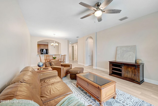 5727 Tamarac Dr, Melbourne, FL 32940 - living area featuring arched walkways, a chandelier, light wood finished floors, and ceiling fan
