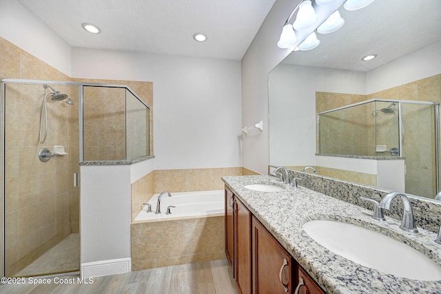 5727 Tamarac Dr, Melbourne, FL 32940 - full bath featuring a bath, a stall shower, double vanity, wood finished floors, and recessed lighting
